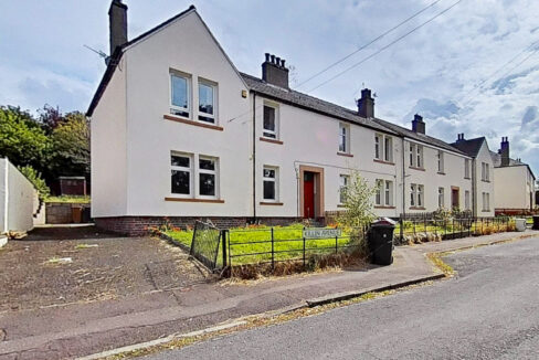 Row of white terraced houses with chimneys along a sunny street; foreground shows a black gate and a street sign reading 'Killin Avenue'